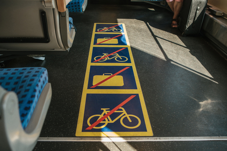 View inside the modern train to the corridor with signs prohibiting putting luggage and bicycles in the passageの写真素材