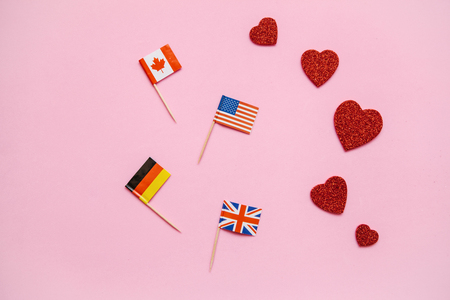 Flags of different countries on a pink background. Concept of friendship between countries, love and peace.の写真素材