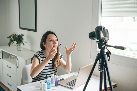 A beauty blogger or video blogger tells and shows subscribers how to do makeup.の写真素材