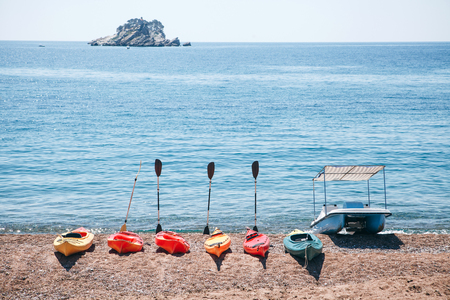 Multi-colored kayaks or canoes on the beach by the sea. Summer fun. Boating on the sea.の写真素材