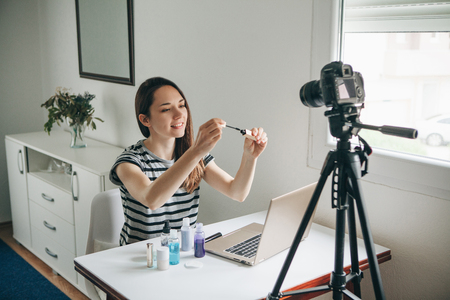 A beauty blogger or video blogger tells and shows subscribers how to do makeup.の写真素材