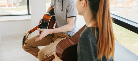 Learning to play the guitar. Extracurricular activities or tutoring or hobbies or creative activities.の写真素材