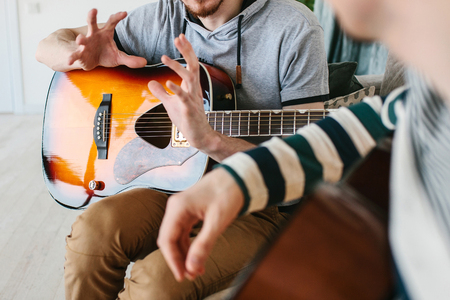 Learning to play the guitar. Extracurricular activities or tutoring or hobbies or creative activities.の写真素材