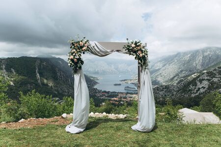 Beautiful wedding arch with flowers on the background of the Boko-Kotor Bay in Montenegro. Preparation for a wedding event.の写真素材