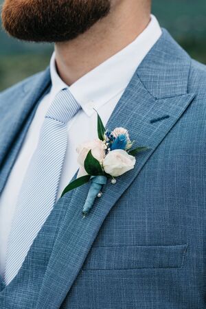Closeup of a boutonniere on a suit of the groom.