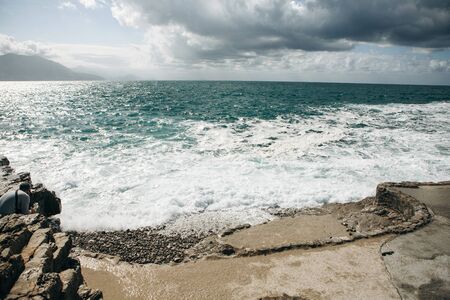 Beautiful view of the restless sea near the stone coast. Natural landscape