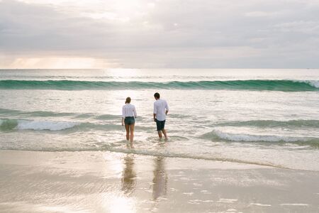 A man and a woman walk together along the seashoreの写真素材