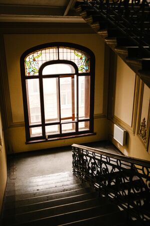 Inside a residential building with a staircase and a window.の写真素材