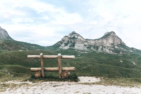 Wooden bench on the background of the mountain called Saddle in Montenegro.の写真素材