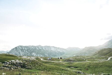 Beautiful view of the mountainous natural landscape in Montenegro. View of the mountains, asphalt road and authentic wooden houses.の写真素材