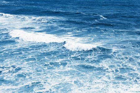 View of the blue sea or ocean with foam and waves background.の写真素材