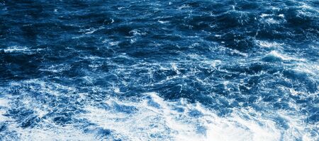 View of the blue sea or ocean with foam and waves background. View from aboveの写真素材