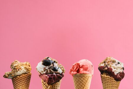 Various ice cream in waffle cones on a pink background.の写真素材