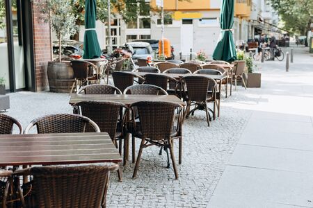 Empty tables and chairs of a street cafe in Berlin in Germanyの写真素材