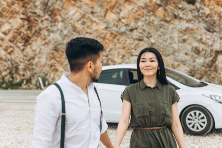 Young beautiful couple. They look at each other and are in love. They are on a road trip. A man leads a woman along.の写真素材