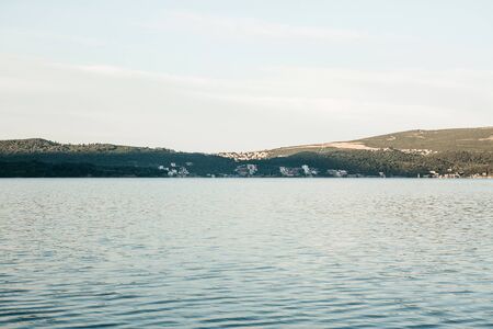 Beautiful view of the sea and the rolling hills and coastal city in Montenegro in the morning.の写真素材