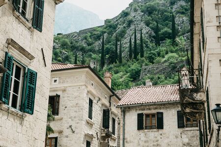 View of traditional houses against the backdrop of the mountains in Kotor in Montenegro.の写真素材