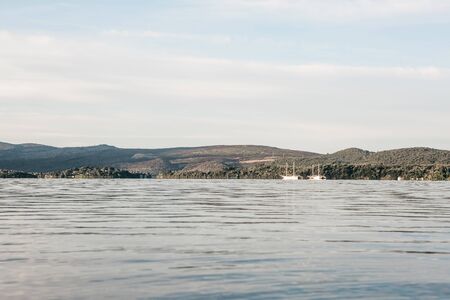 A beautiful view of the sea and rolling hills and yachts in the distance in Montenegro in the morning.の写真素材