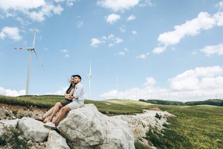 A young couple sits together, hugs and dreams.の写真素材