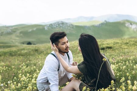A guy with his girlfriend in the field. She hugs him and they are going to kiss. Intimate relationships and love.の写真素材