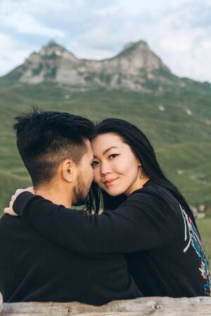 Portrait of an attractive girl hugging with her boyfriend on a background of a mountain landscape in Montenegro.の写真素材
