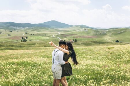 Woman with man cuddling in the field. Intimate relationships and love.の写真素材