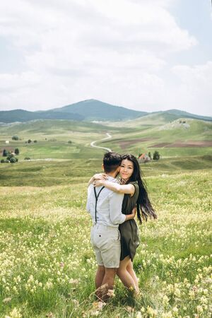 Portrait of a beautiful young adult girl hugging a manの写真素材