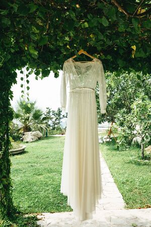 Wedding dress hanging on a hanger outdoor. Preparing for the wedding.の写真素材