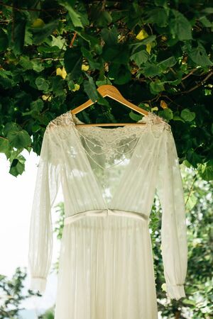 Wedding dress hanging on a hanger outdoor. Preparing for the wedding.の写真素材