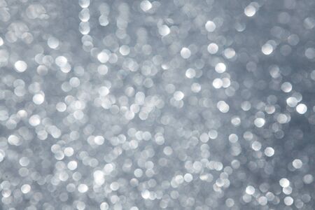 Festive silver abstract background with colorful defocused circular bokeh.の写真素材