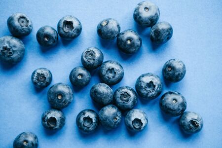 Useful and tasty blueberries on a blue background. Berry or fruit background.の写真素材