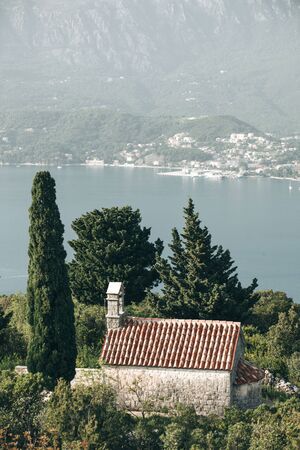 View of a secluded church among the trees by the sea in Montenegroの写真素材