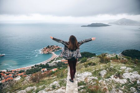 The girl raises her hands up. She admires the beautiful view   in Montenegro.の写真素材