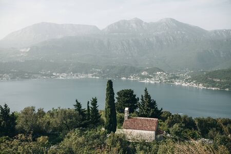 View of a secluded church among the trees by the sea in Montenegroの写真素材
