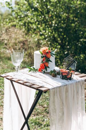 Freshly decorated wedding and celebration cake on a table outdoors.の写真素材