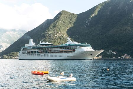 A cruise ship sails on the sea against the backdrop of the mountain in the Bay of Kotor in Montenegro.の写真素材