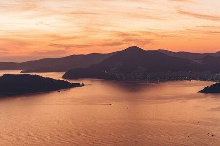 Beautiful view of the sunset and the natural landscape with the sea and mountains in Montenegro.の写真素材