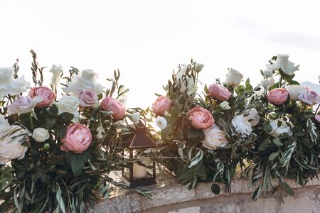Many flowers and a candle in a candlestick as decorations.の写真素材