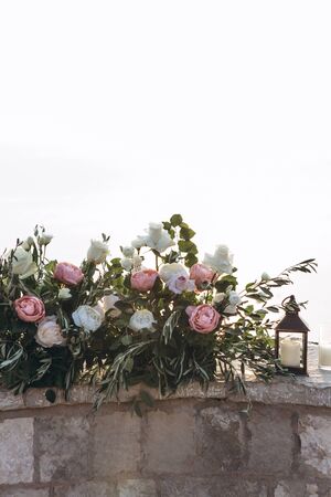 Many flowers and a candle in a candlestick as decorations.の写真素材