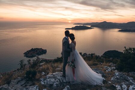 The bride and groom admire the beautiful natural landscape in Montenegro near the islandの写真素材