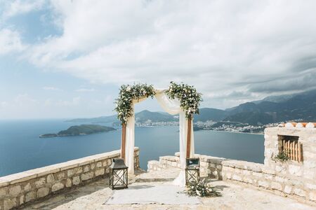 Beautiful wedding arch with flowers on the background of the sea in Montenegro. Preparation for a wedding event.の写真素材