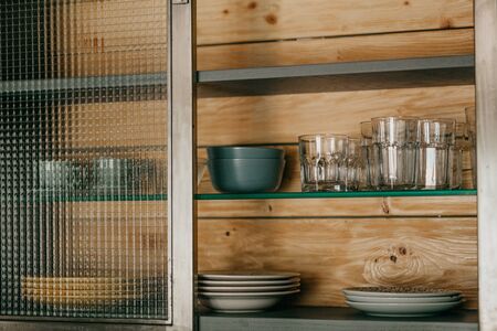 Clean plates and glasses on a shelf in the closet.の写真素材