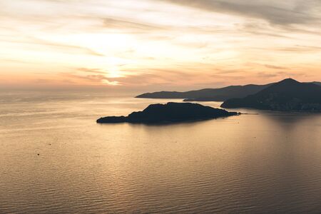 Beautiful view of the sunset and the natural landscape with the sea and hills or mountains in Montenegro in the summer.の写真素材