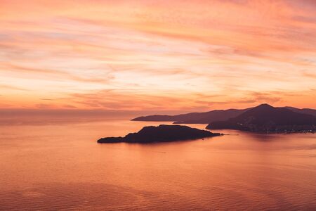 Beautiful view of the sunset and the natural landscape with the sea and hills or mountains in Montenegro.の写真素材