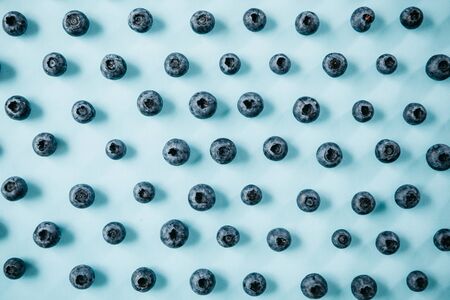 Useful and tasty blueberries on a blue background. Berry or fruit background.の写真素材