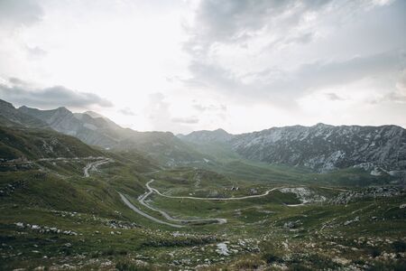 Beautiful view of the mountainous natural landscape in Montenegro. View of the mountains and the asphalt road through the valley.の写真素材