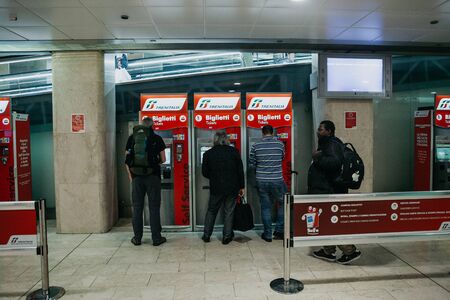 Italy, Milan, July 12, 2019: People buy tickets at self-service machines at the train station in Milan.のeditorial素材