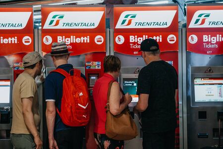 Italy, Milan, July 12, 2019: People buy tickets at self-service machines at the train station in Milan.のeditorial素材