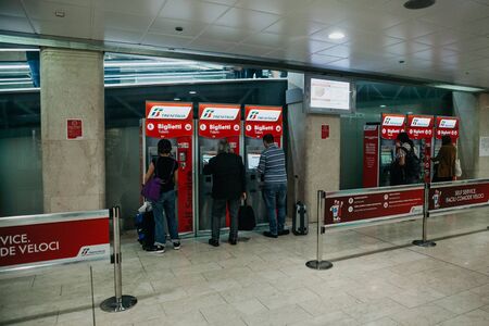 Italy, Milan, July 12, 2019: People buy tickets at self-service machines at the train station in Milan.のeditorial素材