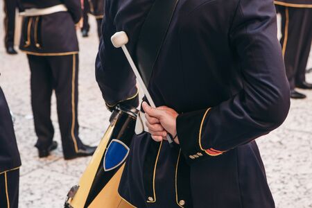 Close-up of the hand of a drummer with a stick for playing the drum. Military Italian drummer getting ready to play music at a performance.の写真素材